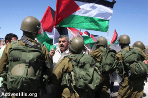Palestinians confront Israeli soldiers at the Huwwara Checkpoint near the Palestinian city of Nablus in protest of Israel’s attack on Gaza. Source: Activestills